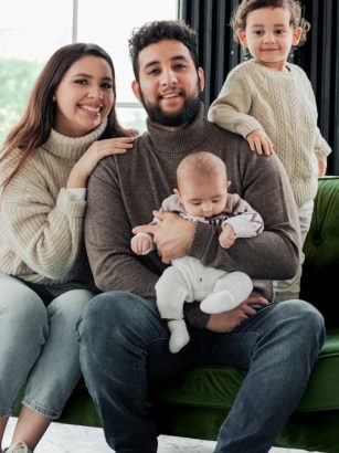 a family sitting on a green couch in a living room