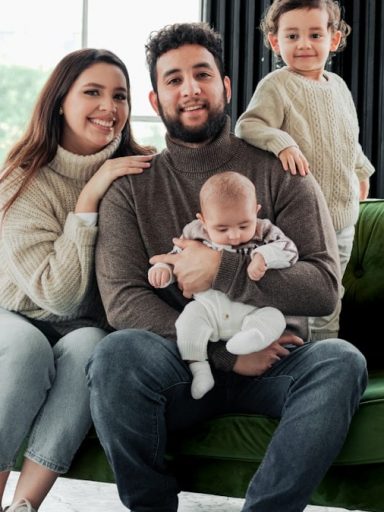 a family sitting on a green couch in a living room