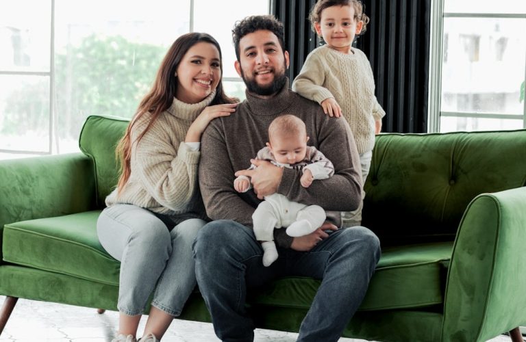 a family sitting on a green couch in a living room